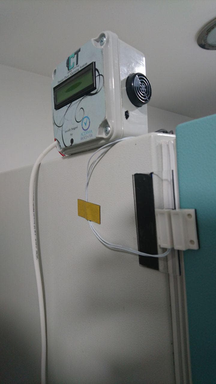 ACDIMA freezer alarm device installed on a freezer door